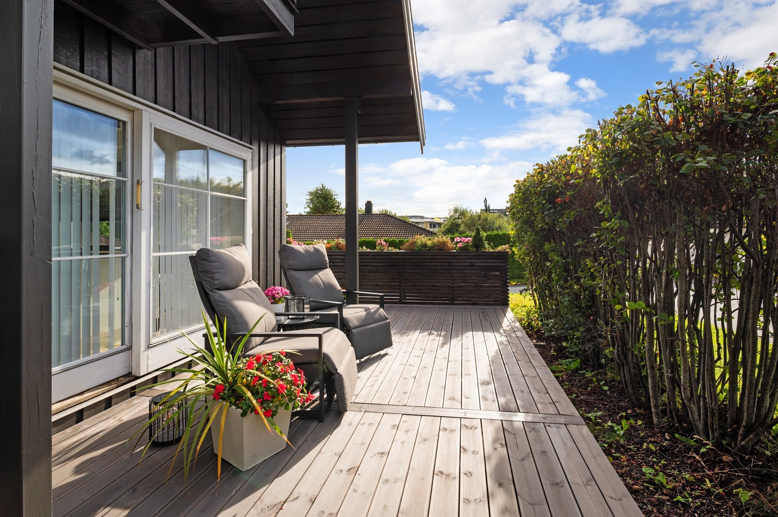 Terrassen måler hele 60,7m² - m.a.o. mer enn god nok plass til flere sittegrupper. Fin hekk mot omgivelsene, samt en plassbygget plantekasse. Galleribilde