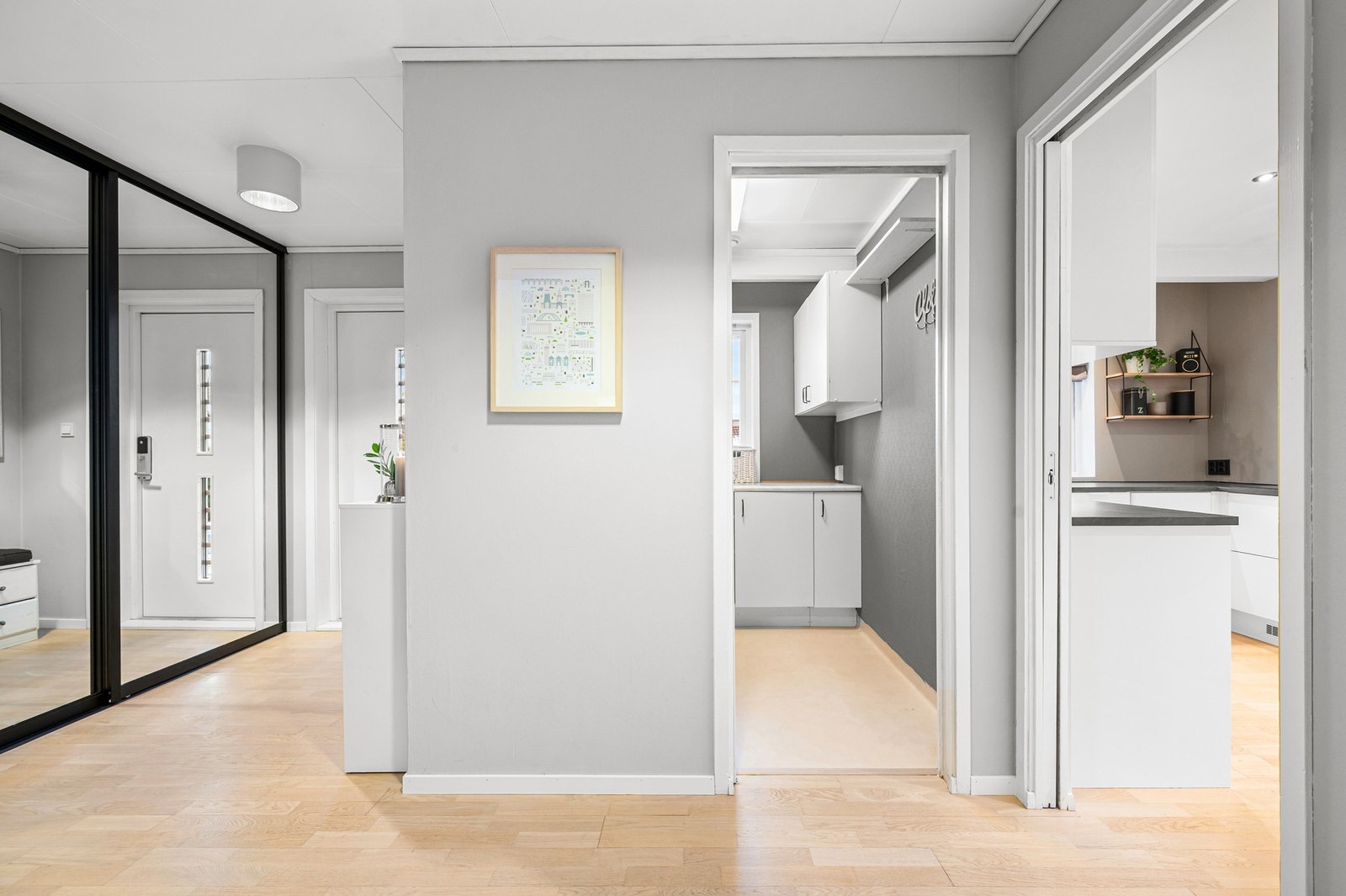 Rett ved inngangspartiet ligger boligens vaskerom - den ideelle planløsningen for en barnefamilie? Skyvedør inn mot både vaskerommet og kjøkkenet fra gangen. Galleribilde