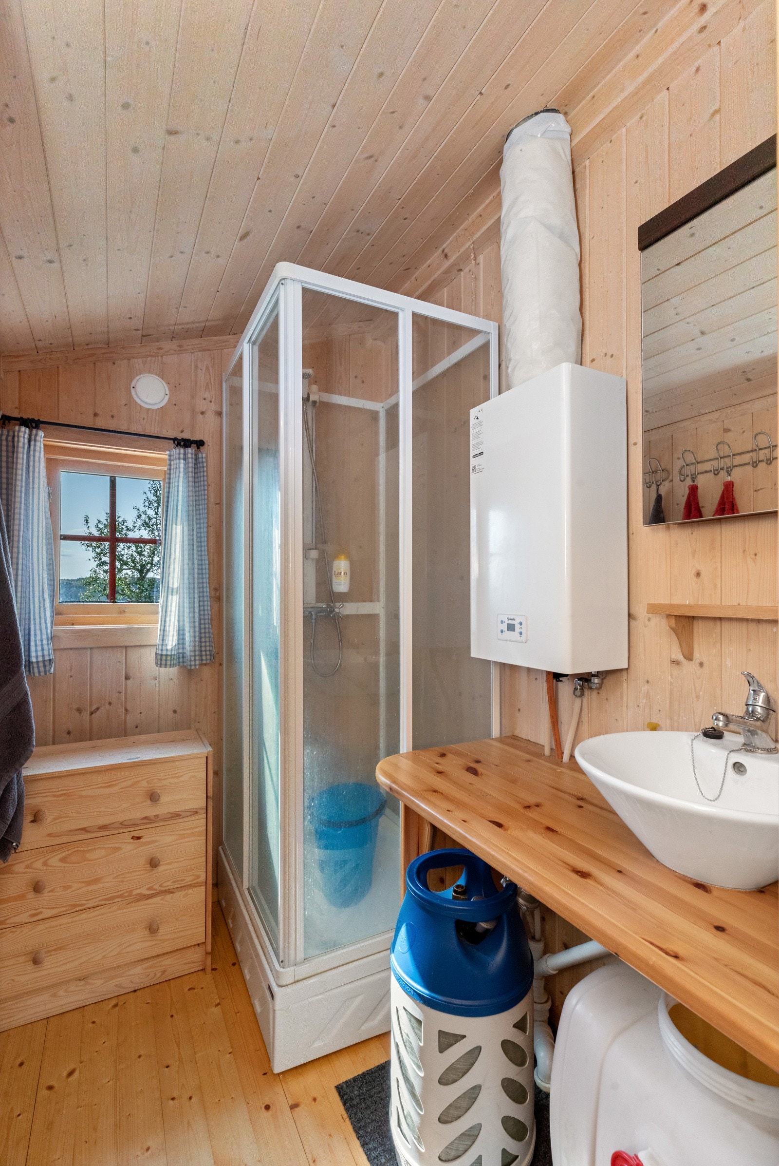 Vanntank under benk på badet.12 volts vannpumpe. Gass vannvarmer Galleribilde