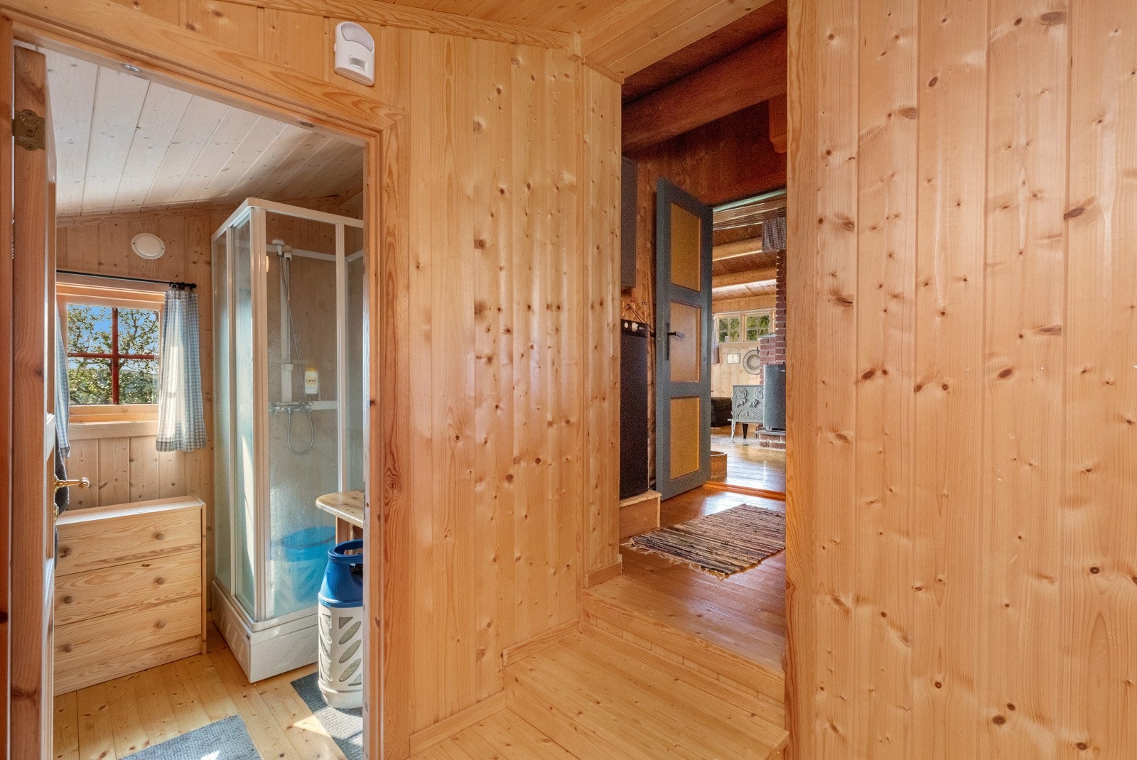 Enkelt hyttebad med heltre benkeplate, speilskap og dusjkabinett Galleribilde