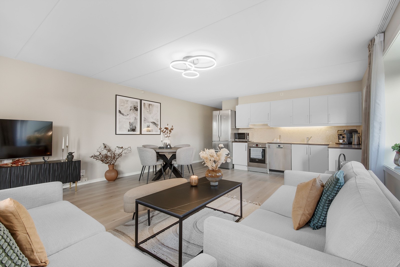 Det åpne stue- og kjøkkenrommet innbyr til både avslapning og sosiale sammenkomster. Galleribilde