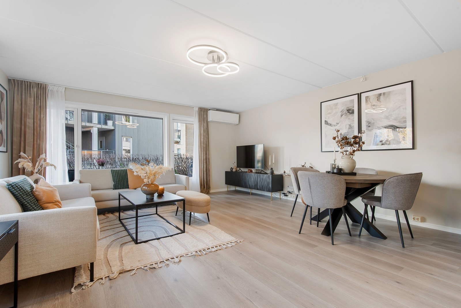 Stuen kan naturlig deles i soner for spisestue og sofaløsning. Fra stuen er det utgang til uteplass med belegningsstein og gress. Fotograf: Marie Waagan. Galleribilde