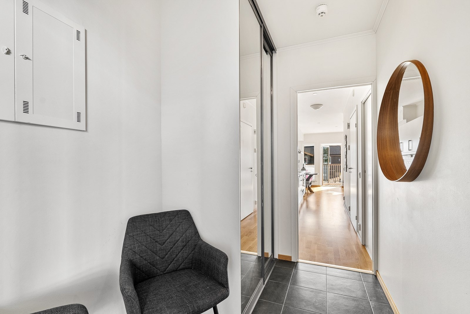 Lys entre med varme i gulv og gode oppbevaringsmuligheter i skyvedørsgarderobe.
Ankomst fra privat ytterdør i felles overbygget svalgang. Galleribilde