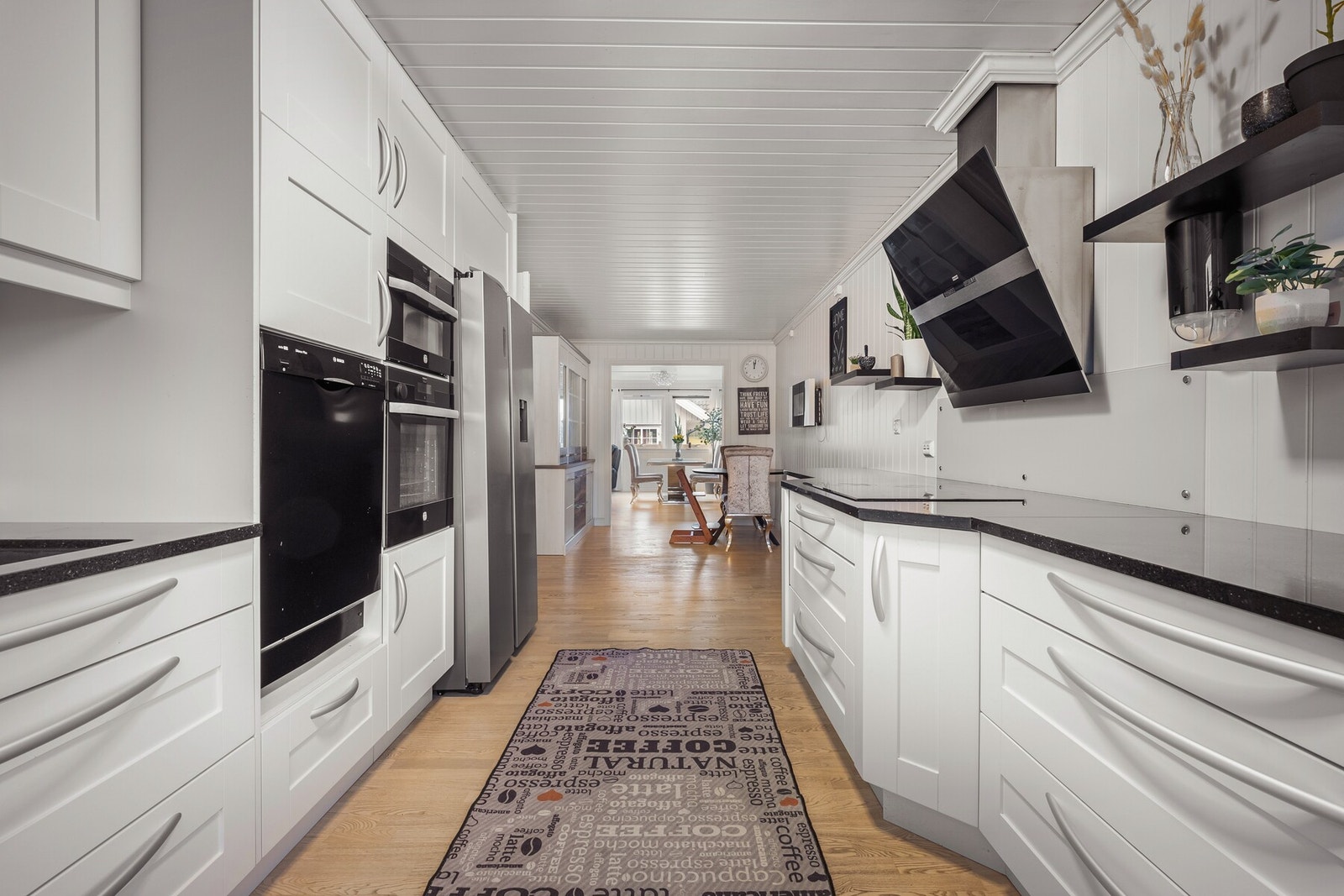 Kjøkkenet byr på rikelig med skapplass og store, elegante benkeplater. Dette gir gode arbeidsforhold og et funksjonelt kjøkken tilpasset både hverdag og middagsbesøk. Galleribilde