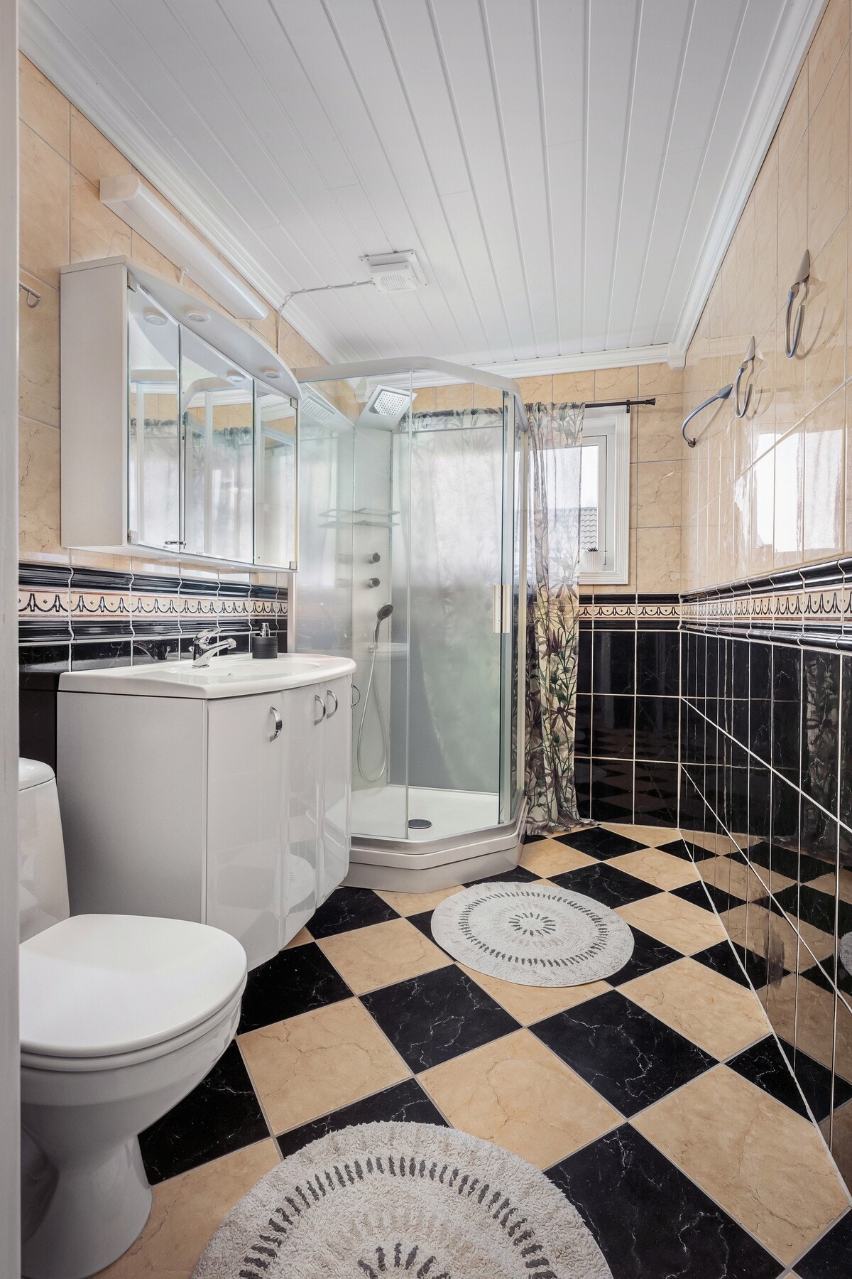 Badet i 1. etasje er flislagt med gulvvarme og byr på rikelig med skapplass. En praktisk løsning for å holde orden i hverdagen. Galleribilde