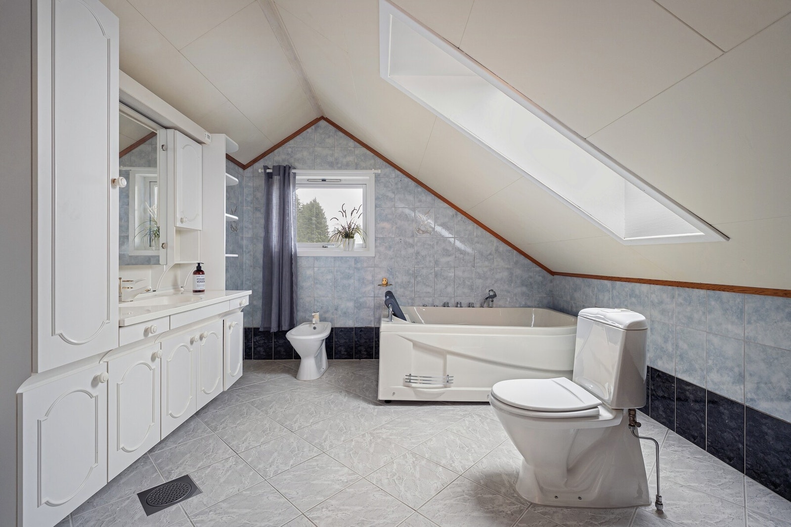 Lyst og romslig bad, med badekar, gulvvarme og rikelig med skapplass. Galleribilde