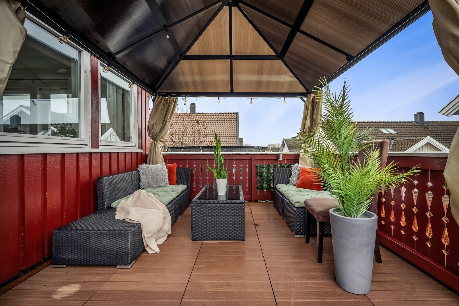 En delevis skjermet og stemningsfull veranda som inviterer til lange sommerkvelder, rolige kaffestunder og hyggelige sammenkomster med familie og venner. Galleribilde