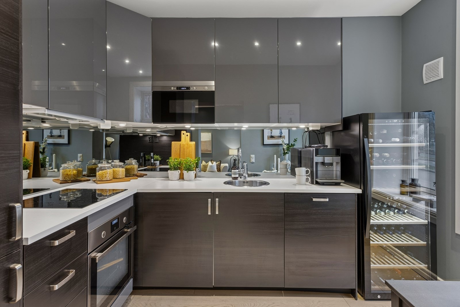 Kjøkkenet er utstyrt med integrert oppvaskmaskin, kjøle- og fryseskap, stekeovn, mikrobølgeovn og induksjonstopp. Galleribilde