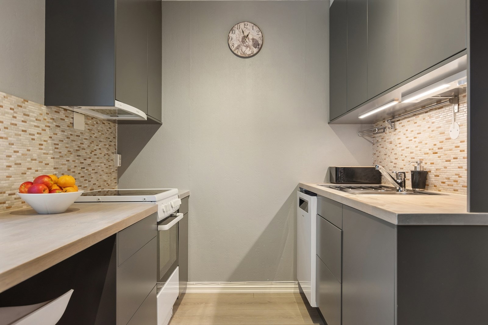 Pent kjøkken med mye skap- og benkeplass. Galleribilde