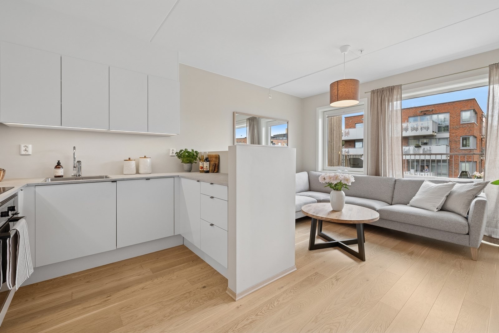 Stuen og kjøkkenet ligger i praktisk åpen løsning og samtidig er det en liten skjermvegg mot stuen som skjermer mot innsyn til kjøkkenbenken. Galleribilde