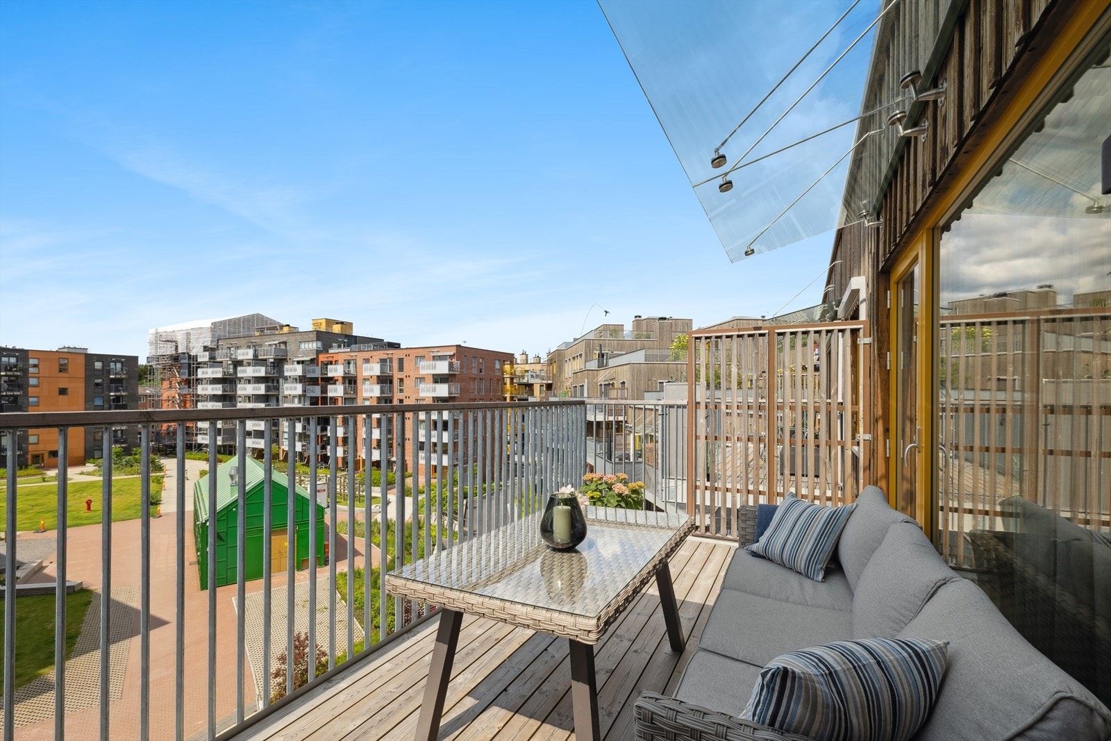 Utsikten fra balkongen over et pent opparbeidet fellesareal. Galleribilde