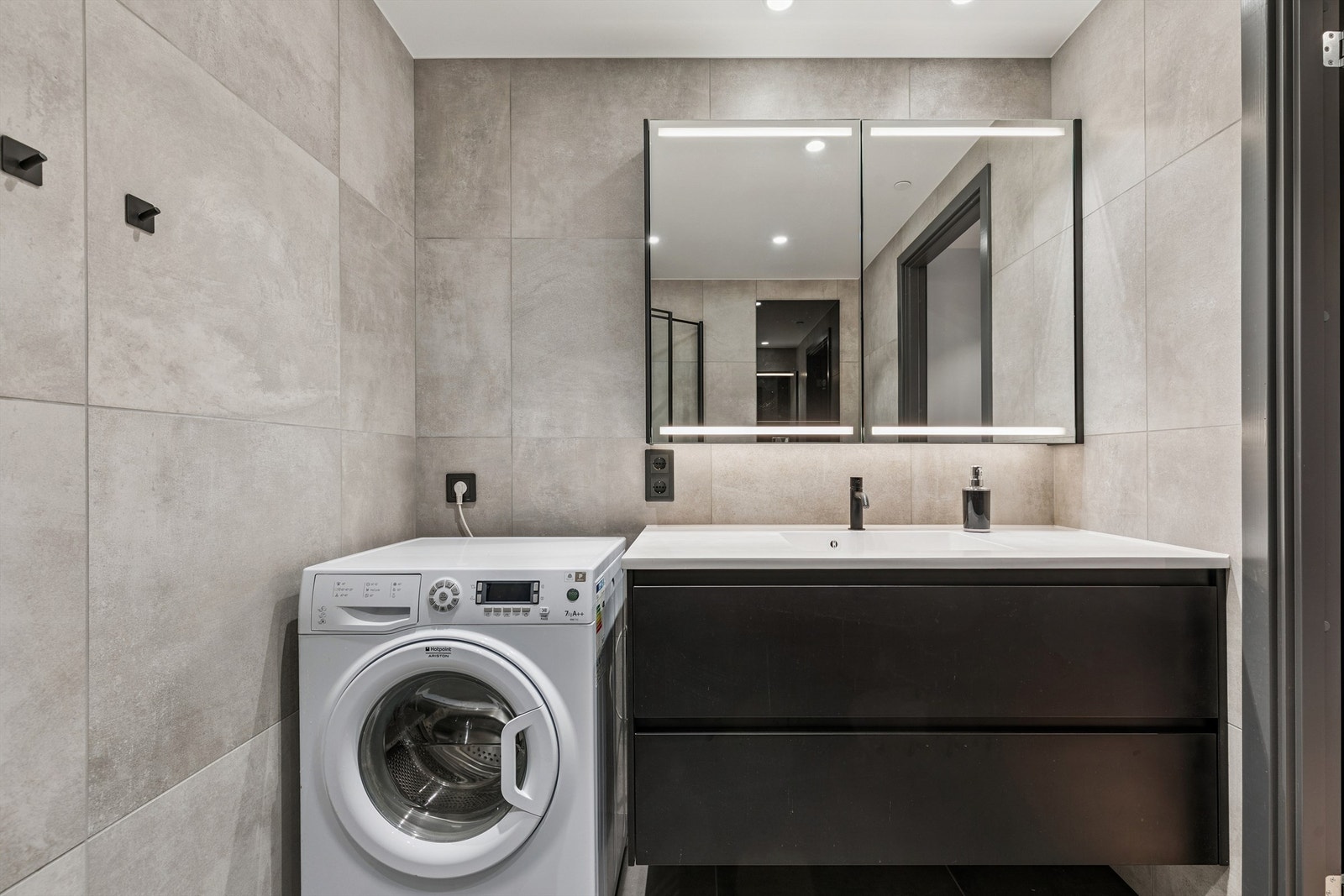 Badet er flislagt og har opplegg for vaskemaskin ved siden av servantinnredningen. Galleribilde