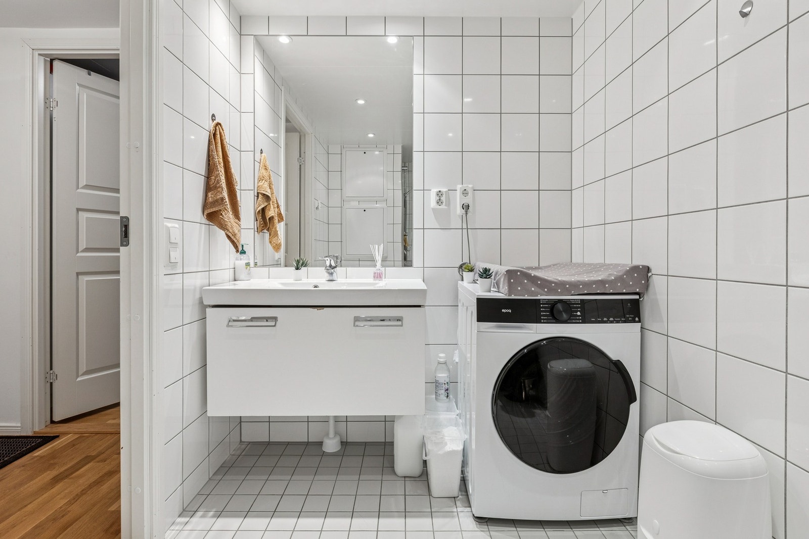 Baderom tilknyttet gangen byr på flislagte vegger og gulv med gulvvarme, en vegghengt servantinnredning med heldekkende servant og en dusjnisje med glassdør samt vegghengt klosett. Galleribilde