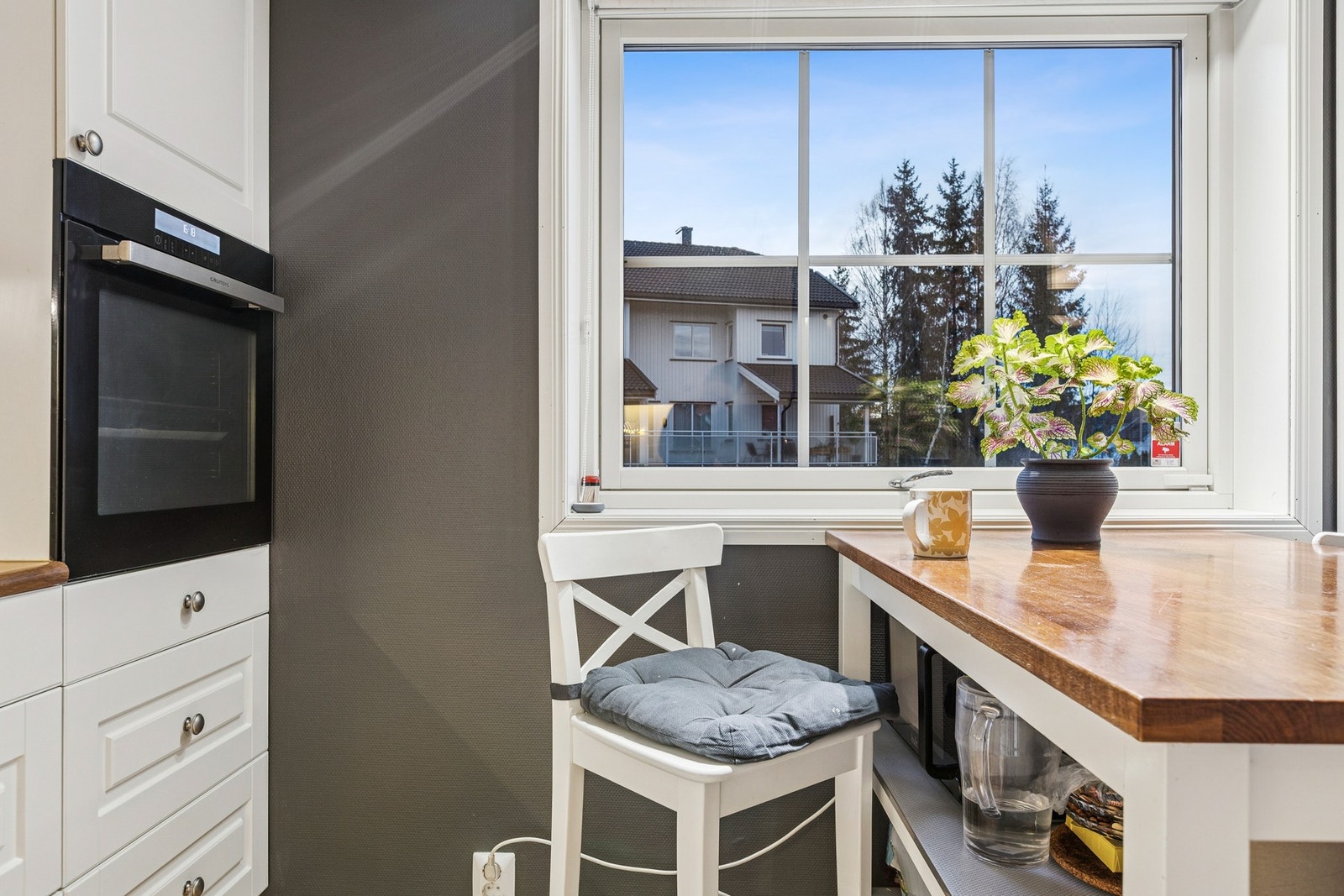 Stor vindusflate ved kjøkkenet slipper inn rikelig med dagslys og skaper en luftig atmosfære. Galleribilde