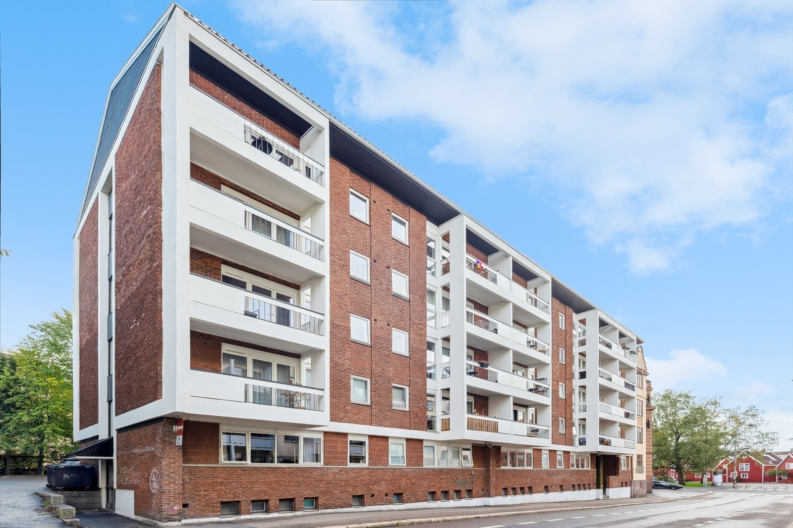 Velholdt og moderne boligblokk i solid murkonstruksjon, med særegne balkongrekker og et ryddig gårdsrom. Galleribilde