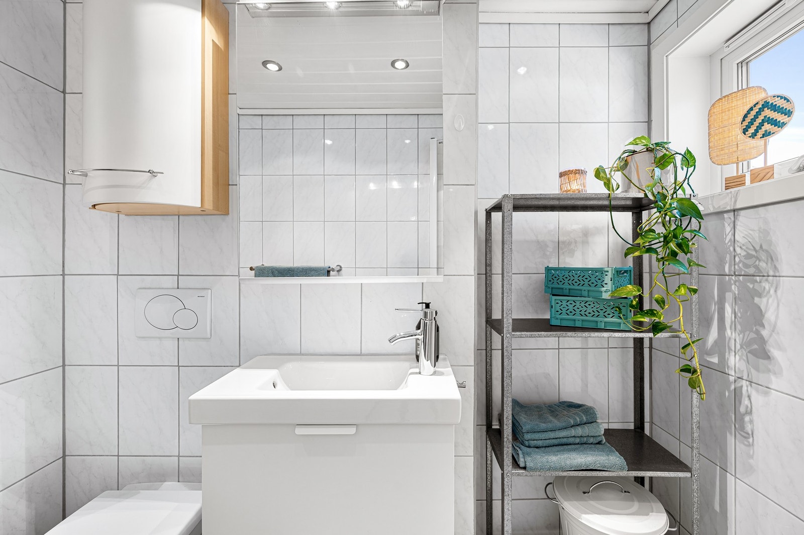 Badet er innredet med dusjhjørne med
innfellbare glassdører og veggmontert toalett. Galleribilde