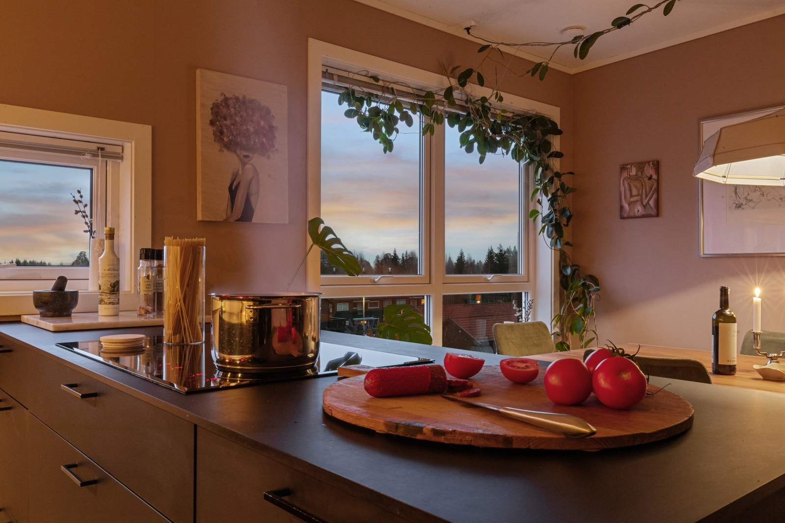 Kjøkkeninnredning fra 2018 med mørke, slette fronter, integrerte hvitevarer og en praktisk kjøkkenøy. Galleribilde