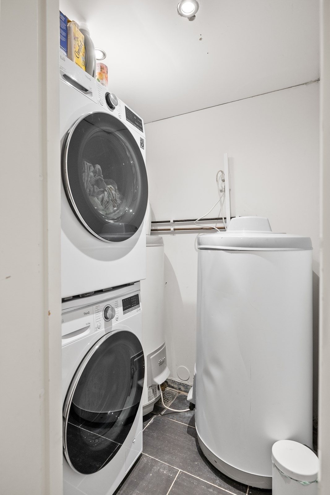 Vaskerommet i kjeller, opplegg for vaskemaskin og tørketrommel. Her finner man også boligens varmtvannstanker. Galleribilde