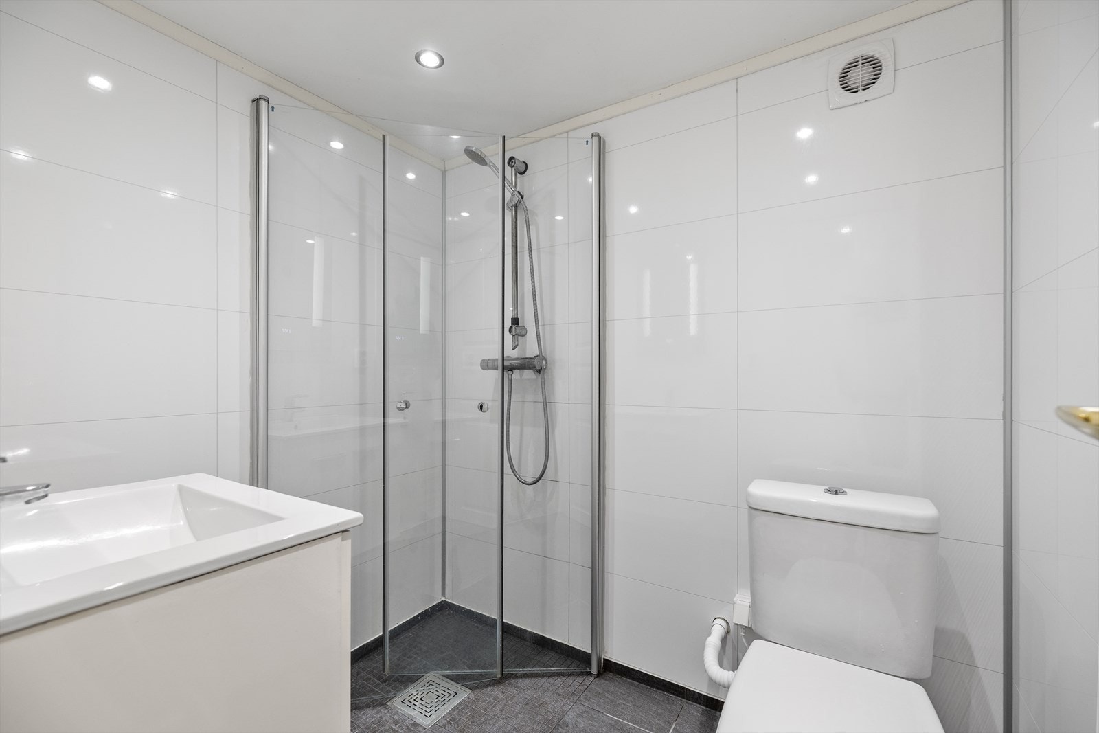 Badet i kjelleren er fra 2021 og har baderomsplater på vegg og flislagt gulv med elektriske varmekabler. Galleribilde