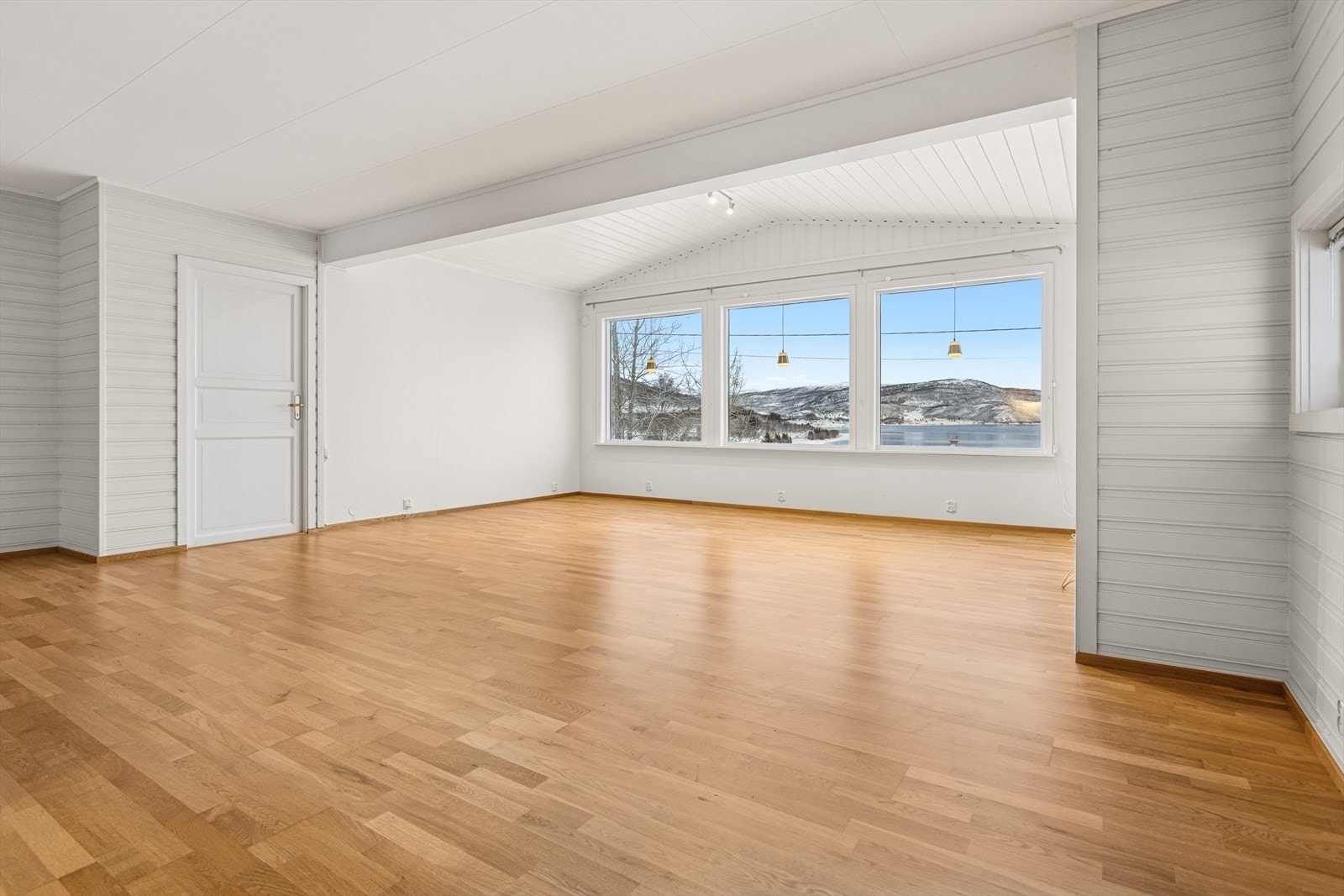 Romslig stue med store vindusflater som gir rikelig med naturlig lysinnslipp. Galleribilde