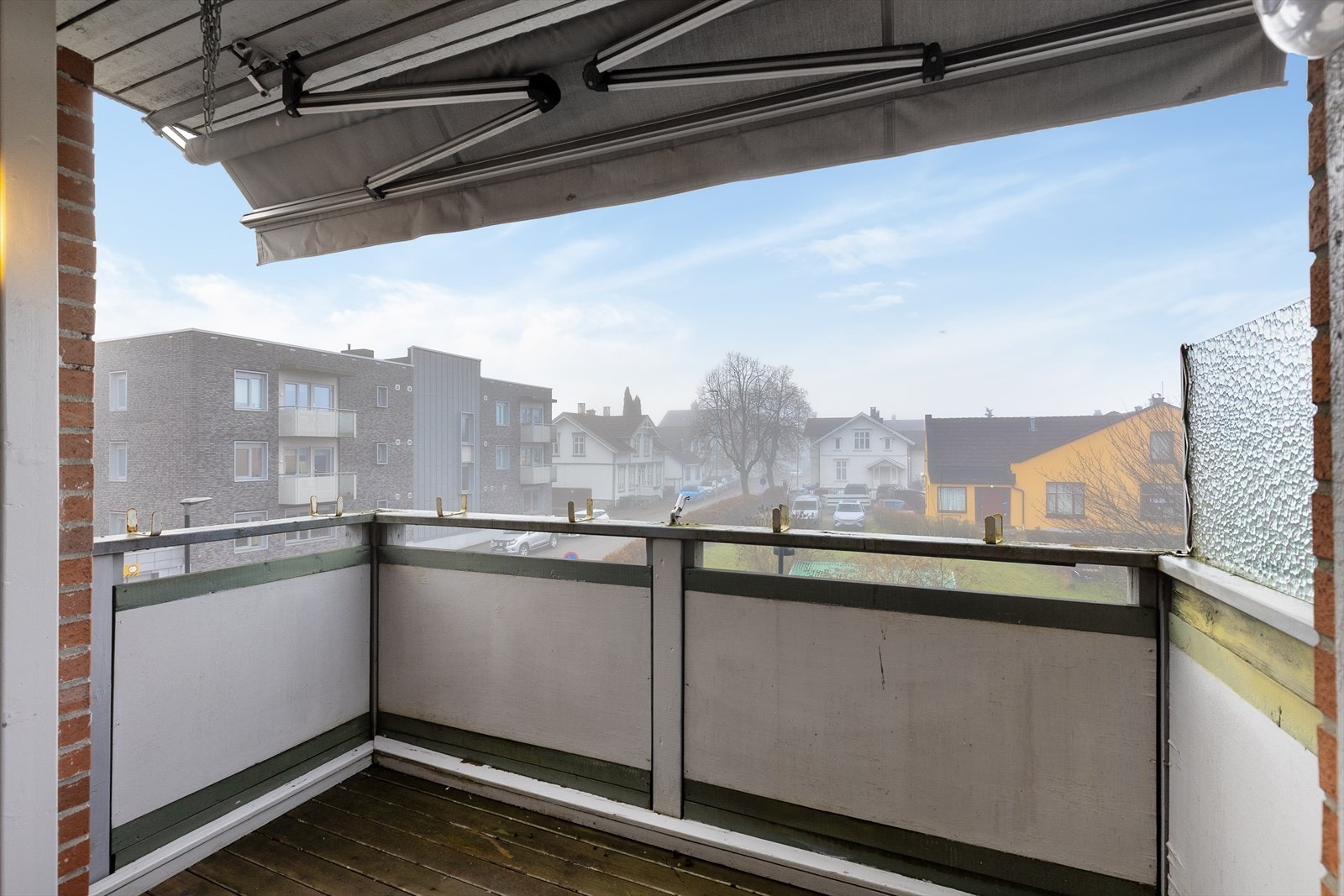 Balkongen er lun og god med takoverbygg og delvis vindskjerming på sidene. Videre er det montert markise for solskjerming her. Galleribilde