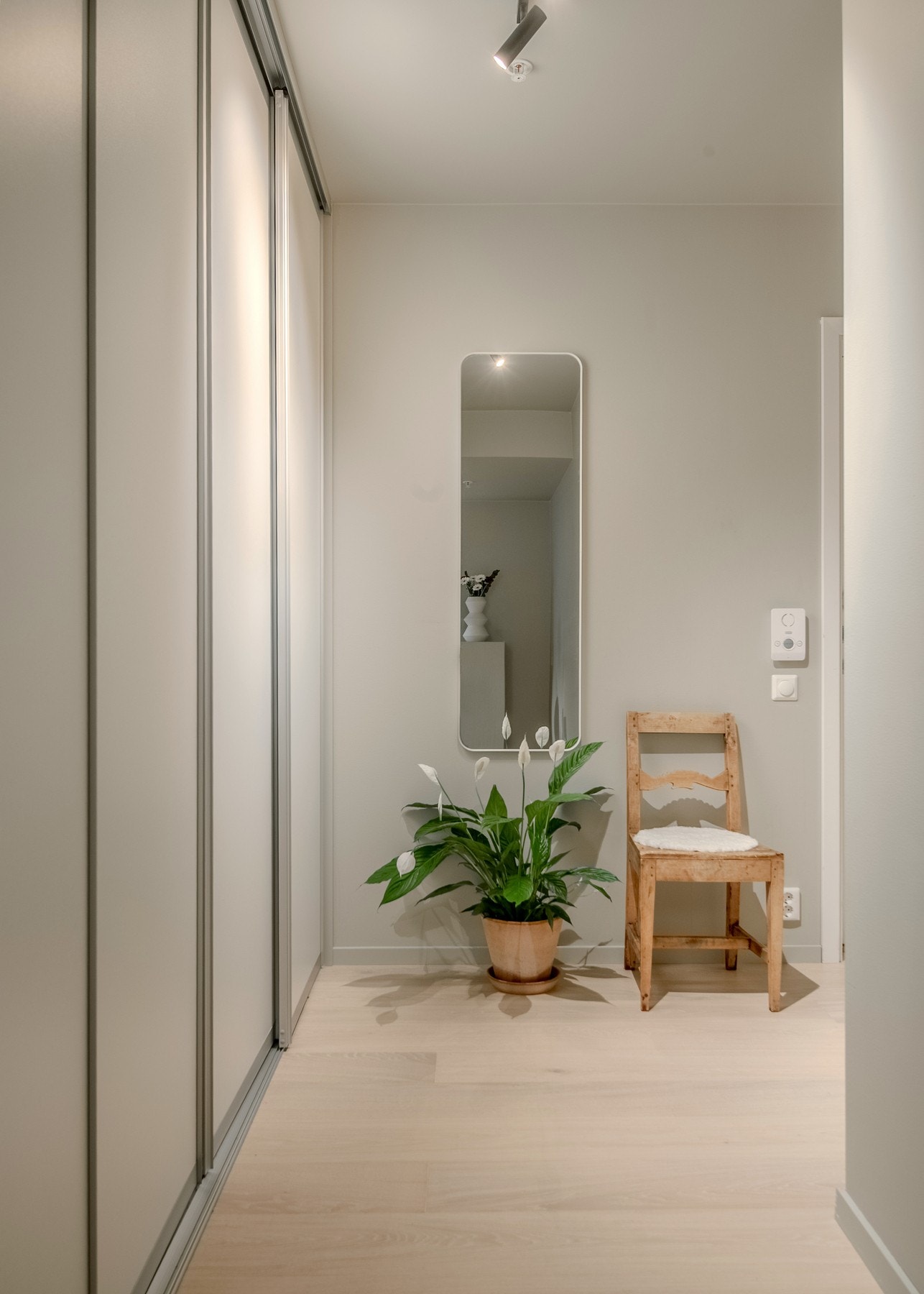Gangen byr på praktisk og skjult oppbevaring i skyvedørsgarderobe med glatte fronter, samt plass for skohylle og oppheng for jakker som gir et ryddig og funksjonelt førsteinntrykk. Galleribilde