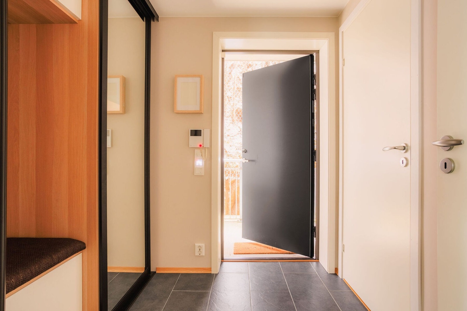 I entréen er det lysmalte glatte veggflater, grå fliser på gulvet med gulvvarme, samt downlights med dimmer i himling i en lys malt farge. Galleribilde