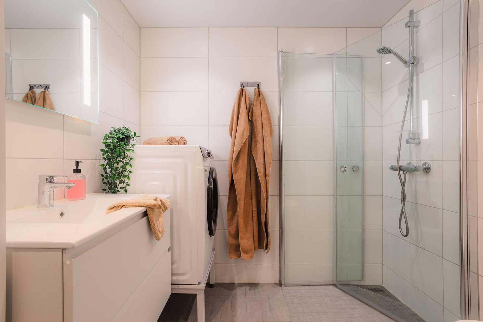 Her får du et høymoderne og lekkert baderom med flislagte vegger og gulv med gulvvarme, samt downlights med dimmer i lysmalt himling. Galleribilde