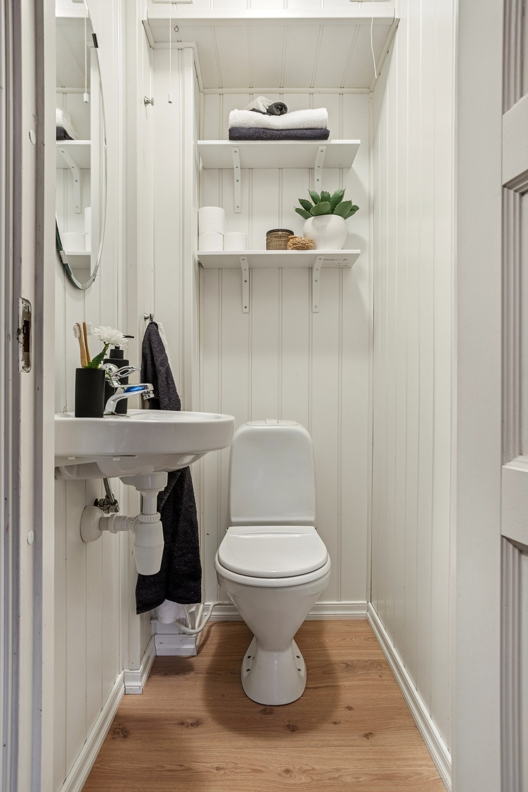 Leiligheten har et separat toalettrom med laminat på gulvet og MDF-plater på veggene. Galleribilde