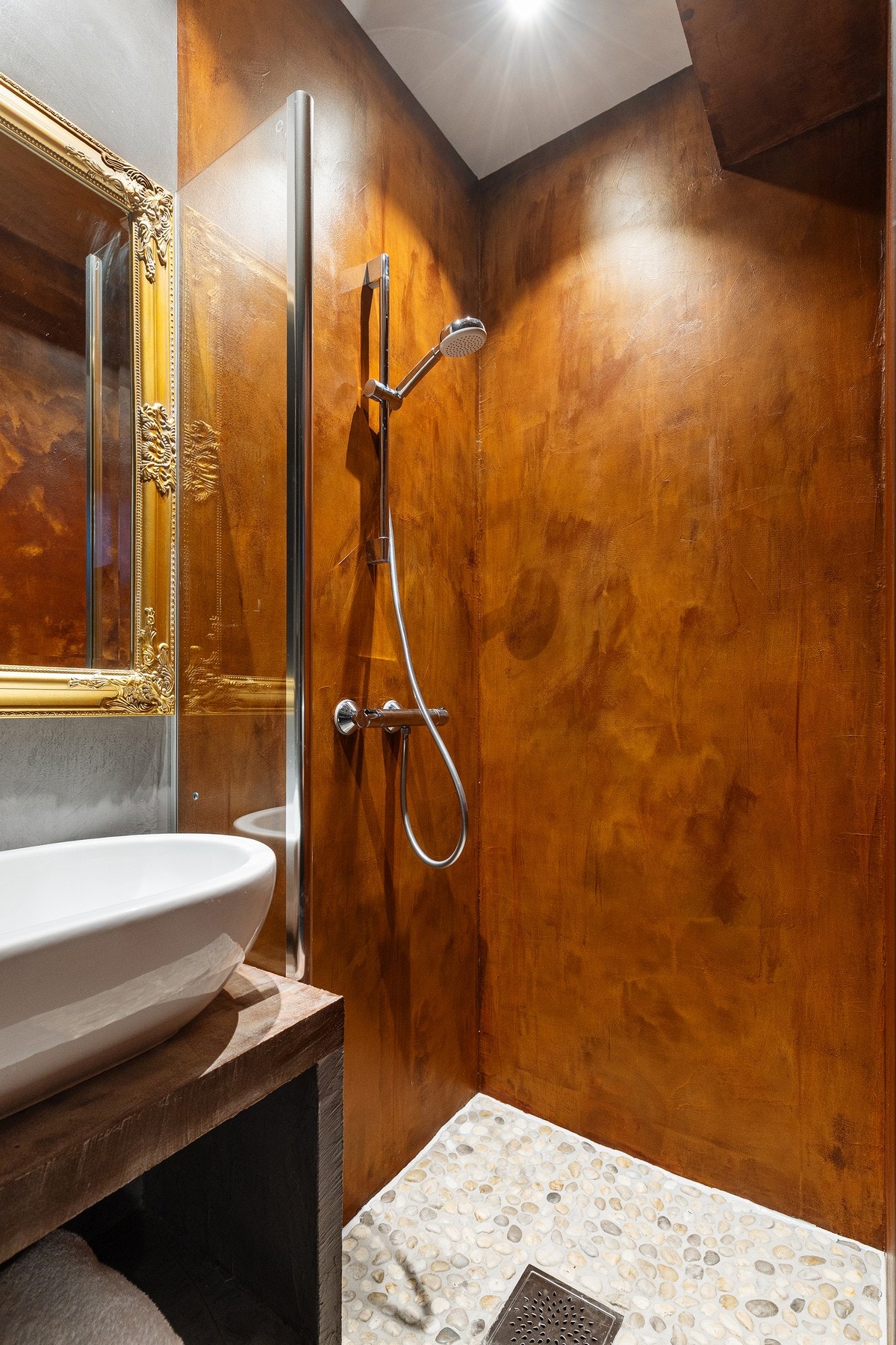 Dusjsonen er utført med elvestein på gulv, mens vegger og øvrige flater er behandlet med mikrosement, noe som gir et sømløst og industrielt uttrykk. Galleribilde