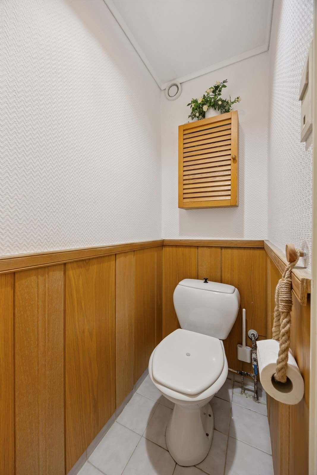 Separat wc-rom med toalett, veggskap og enkel belysning. Praktisk i en hektisk hverdag. Galleribilde