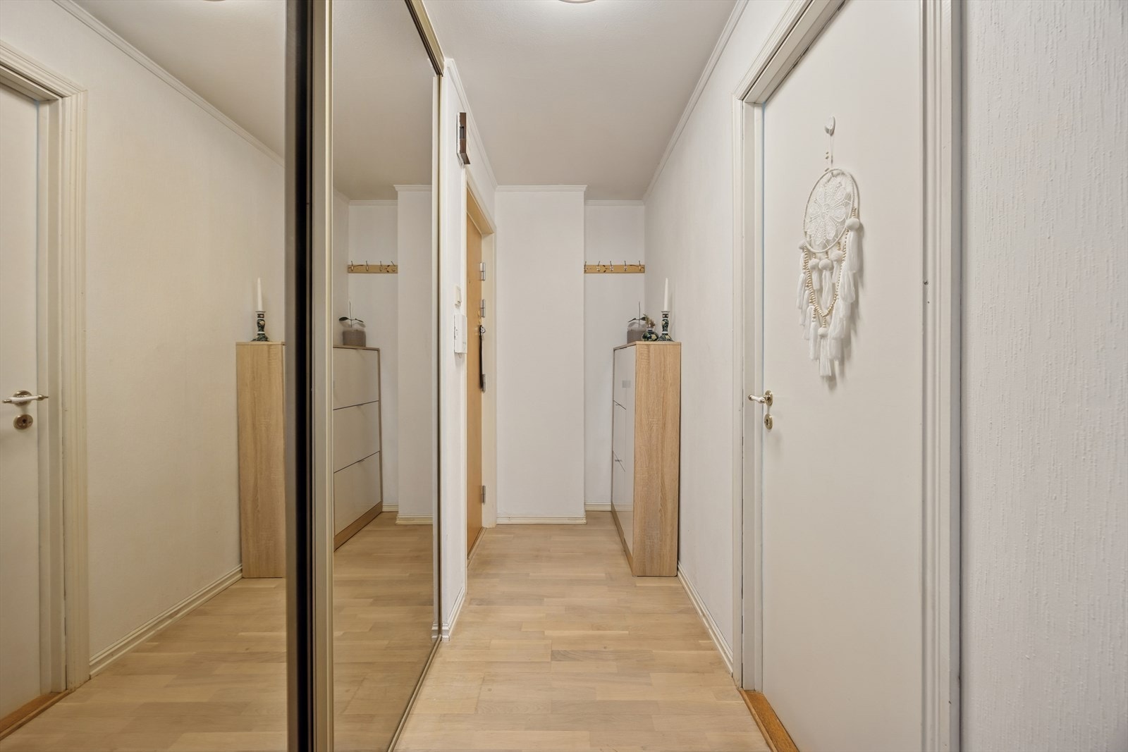 Entreen er praktisk utformet og gir en ryddig velkomst til leiligheten. Her finner du en stor skyvedørsgarderobe med speilfronter som gir god plass til oppbevaring. Galleribilde