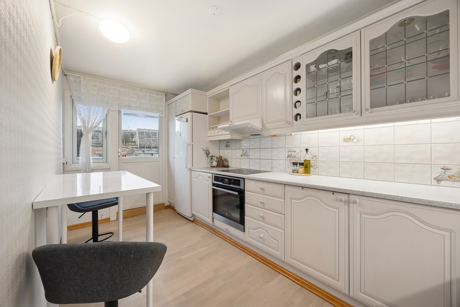 Kjøkkenet er funksjonelt innredet med lyse, profilerte fronter og en praktisk benkeplate i laminat. Galleribilde