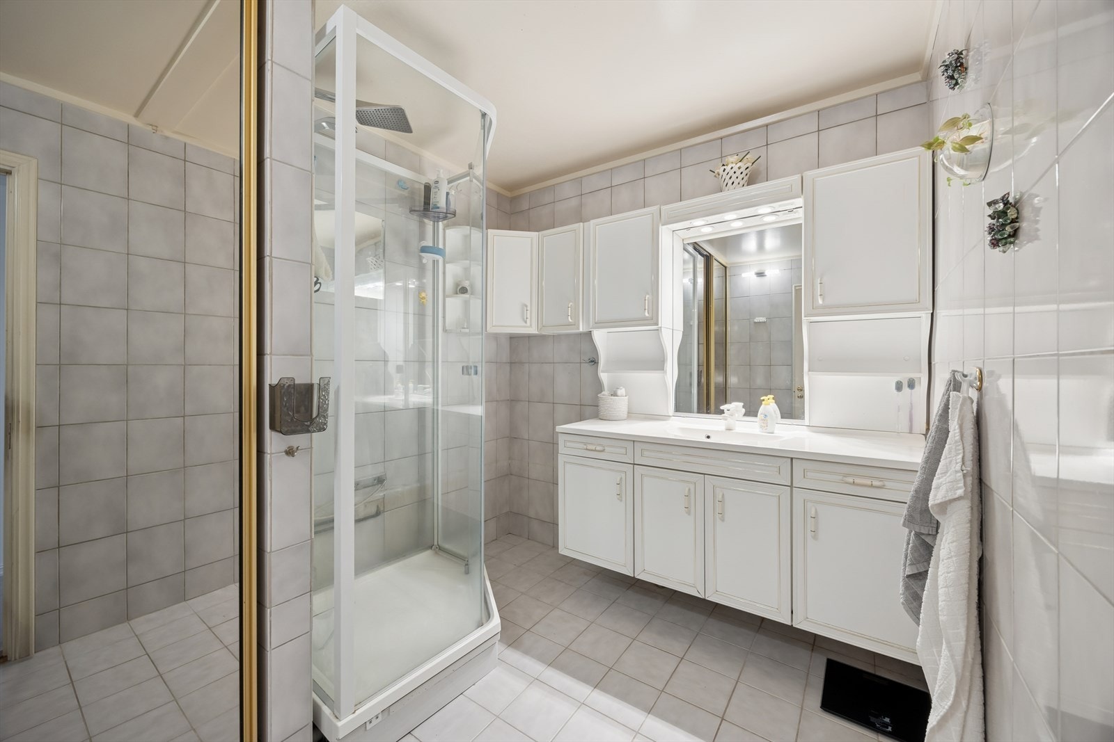 Eldre, men funksjonelt bad innredet med flislagte overflater og behagelige varmekabler i gulvet. Det er opplegg for vaskemaskin. Galleribilde