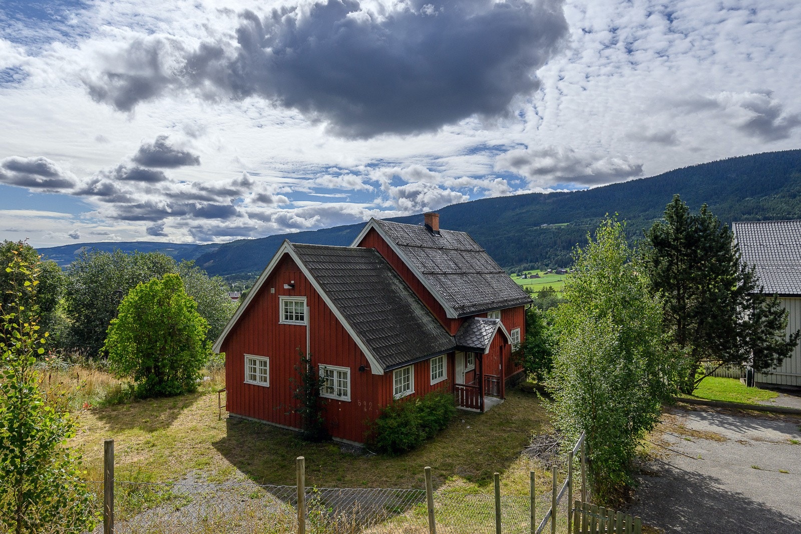 Boligen står på en romslig tomt på et drøyt mål, som er opparbeidet med hage, beplantning og et eldre uthus Galleribilde