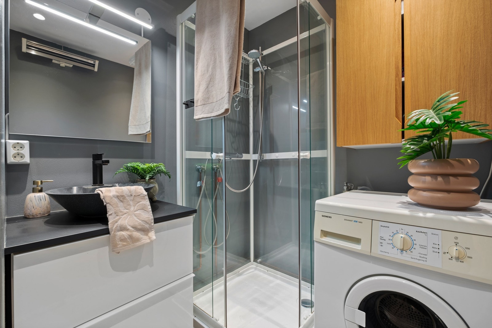 Pent bad på 4,5 kvm med opplegg for vaskemaskin og downlights i himling. Galleribilde