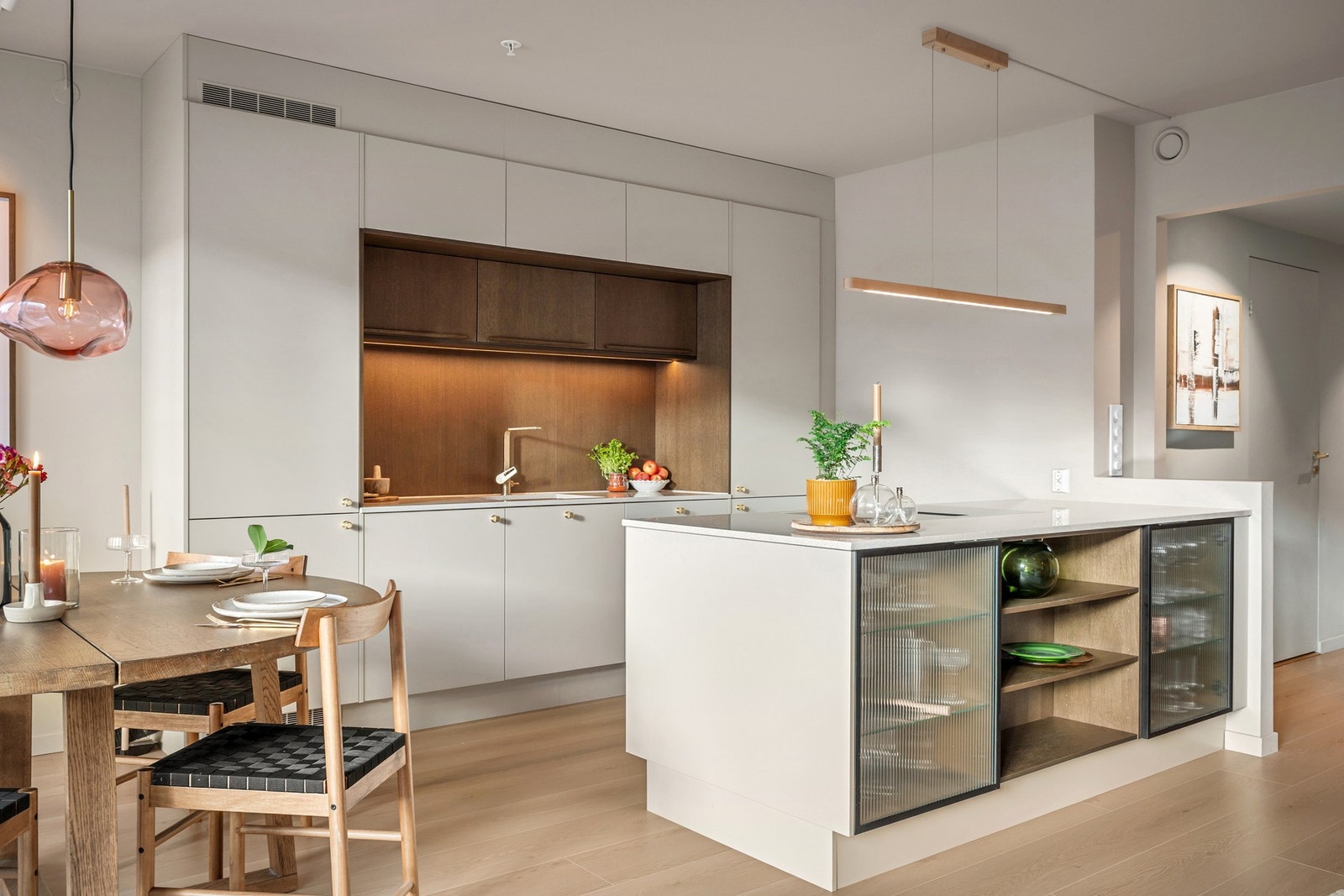 Delikat kjøkkeninnredning med praktisk øy med godt med oppbevaring- og benkeplass. Galleribilde