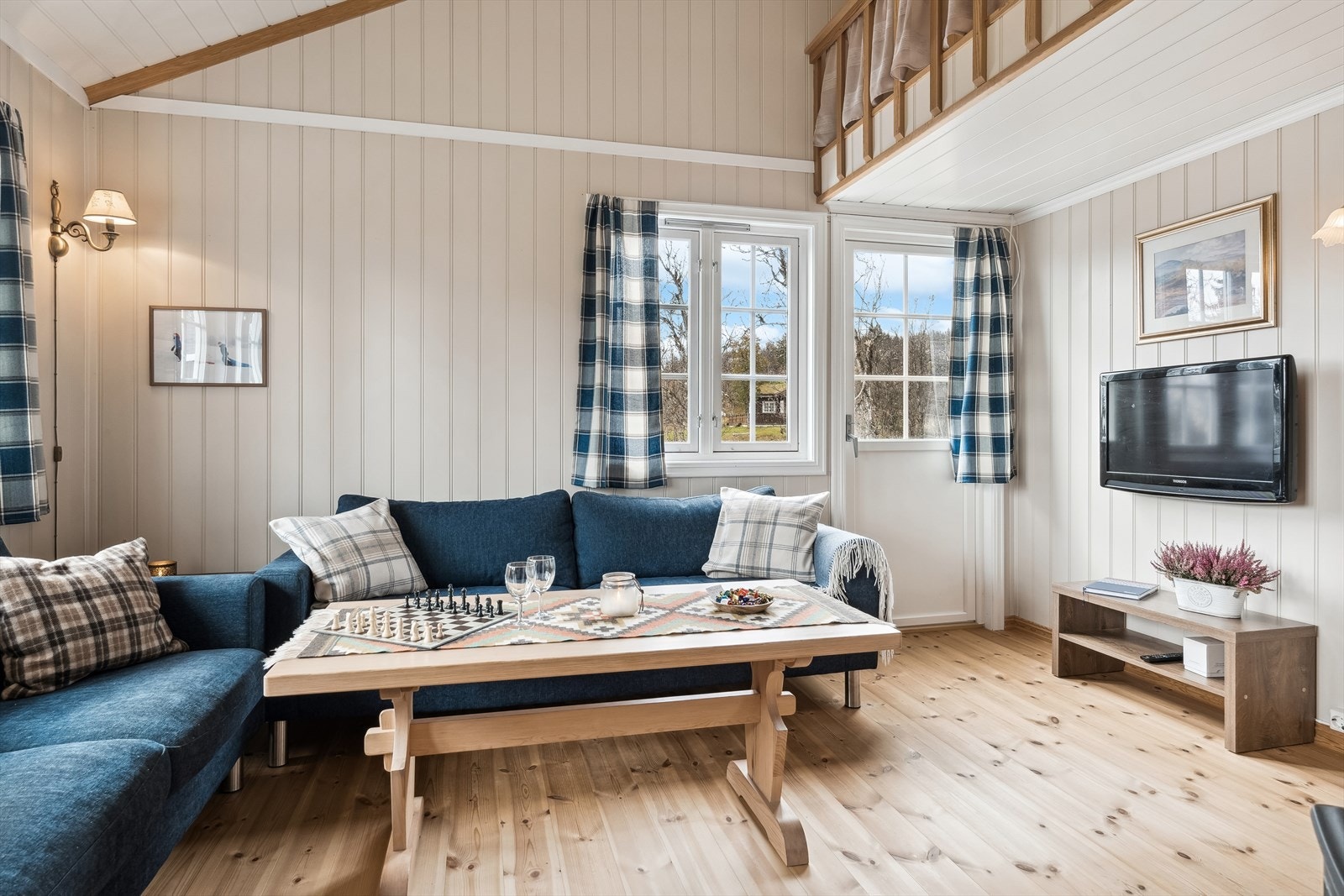 Videre inn fra kjøkkenet finner du en lys og luftig stue med skråtak, mange vinduer og utgang til verandaen. Galleribilde