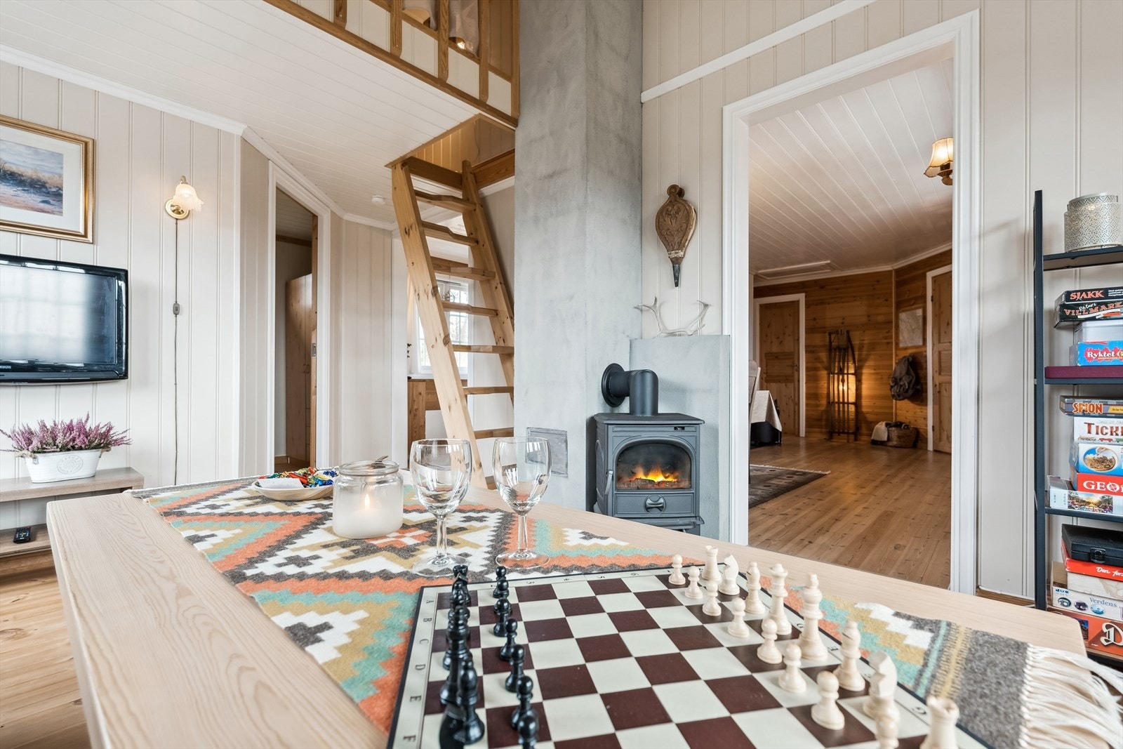 En furutrapp fører opp til hems med åpent rekkverk mot stuen. Galleribilde