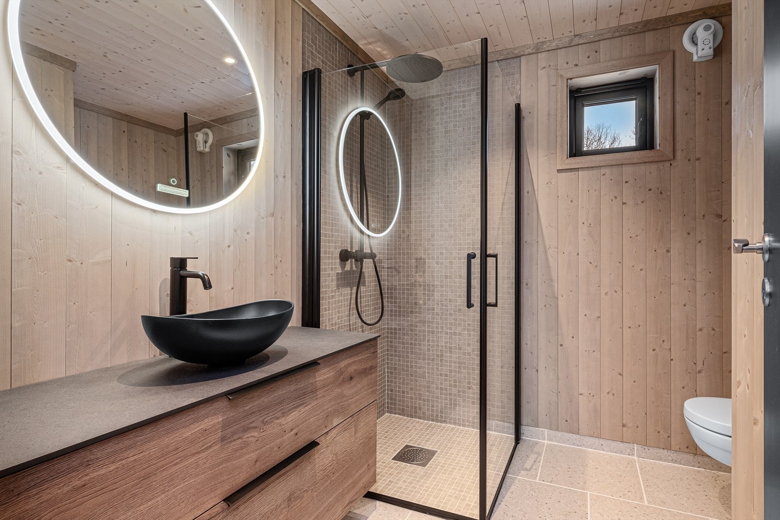 Pent bad med flislagt gulv og flislagt dusjsone. Galleribilde