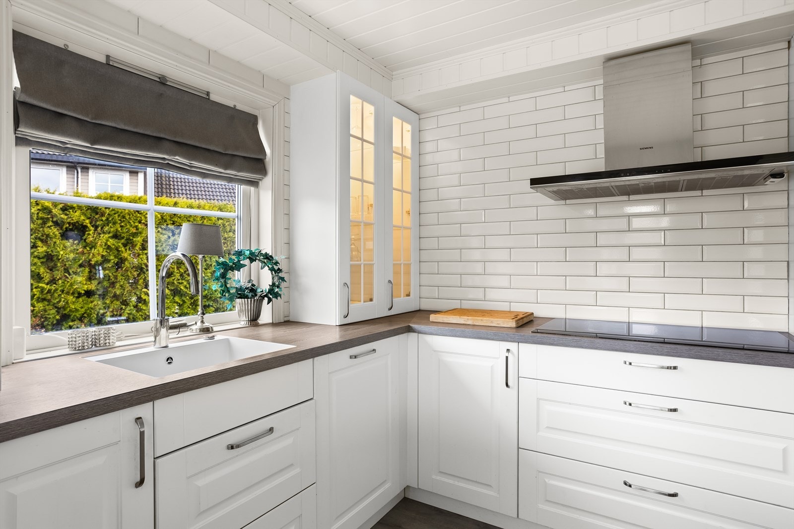 Det er montert fliser mellom benkeplate og overskap, samt en underlimt vask. Galleribilde