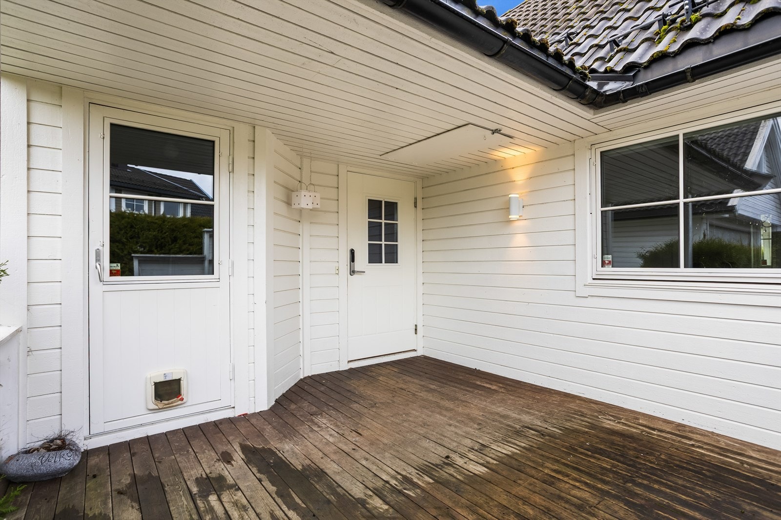 Et overbygget inngangsparti leder inn i boligen. Galleribilde