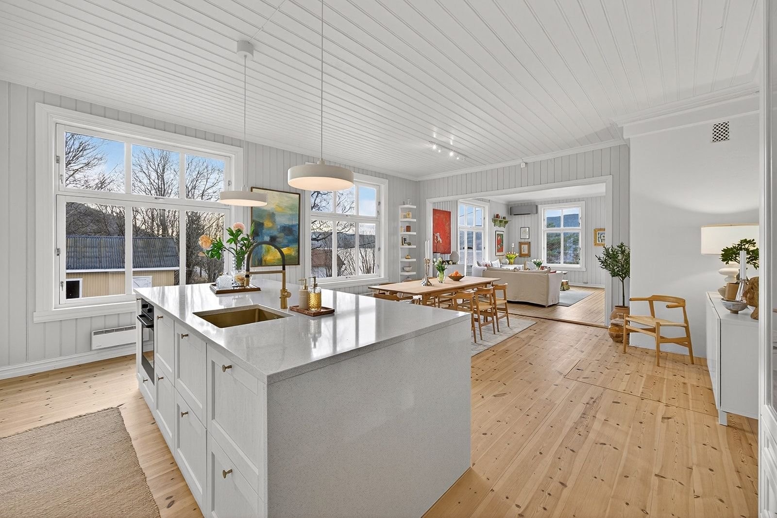 Stor kjøkkenøy belagt med plater i kvarts. Backsplash og benkeplate i samme materiale. Galleribilde