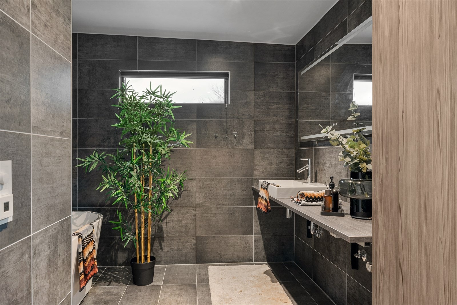 Lekkert bad med god plass, moderne innredning og en rolig spa-følelse. Store flater og gjennomført materialvalg. Galleribilde