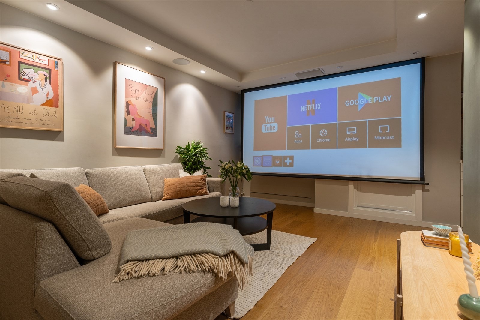 I stuen er det integrert både lerret og høyttalere i taket, som forvandler leiligheten til en hjemmekino Galleribilde