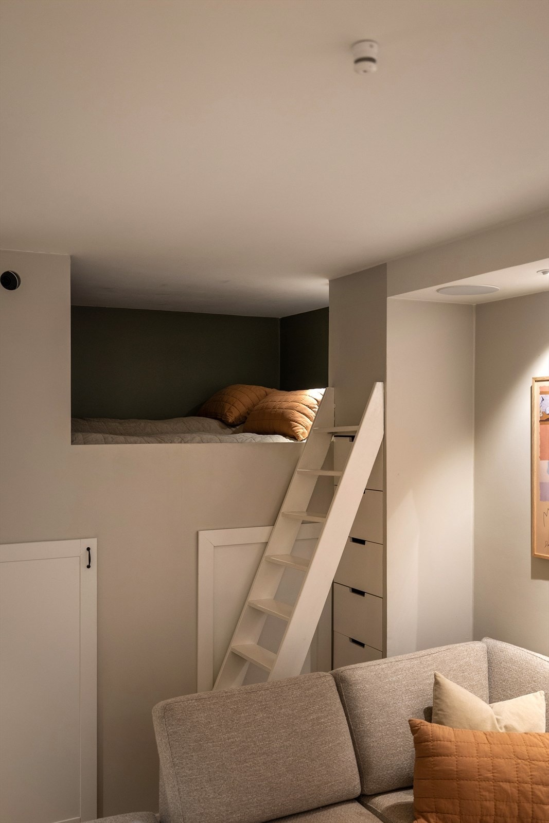 Arealeffektiv sovealkove i enden av stuen, med god lagringsplass i rommet under Galleribilde
