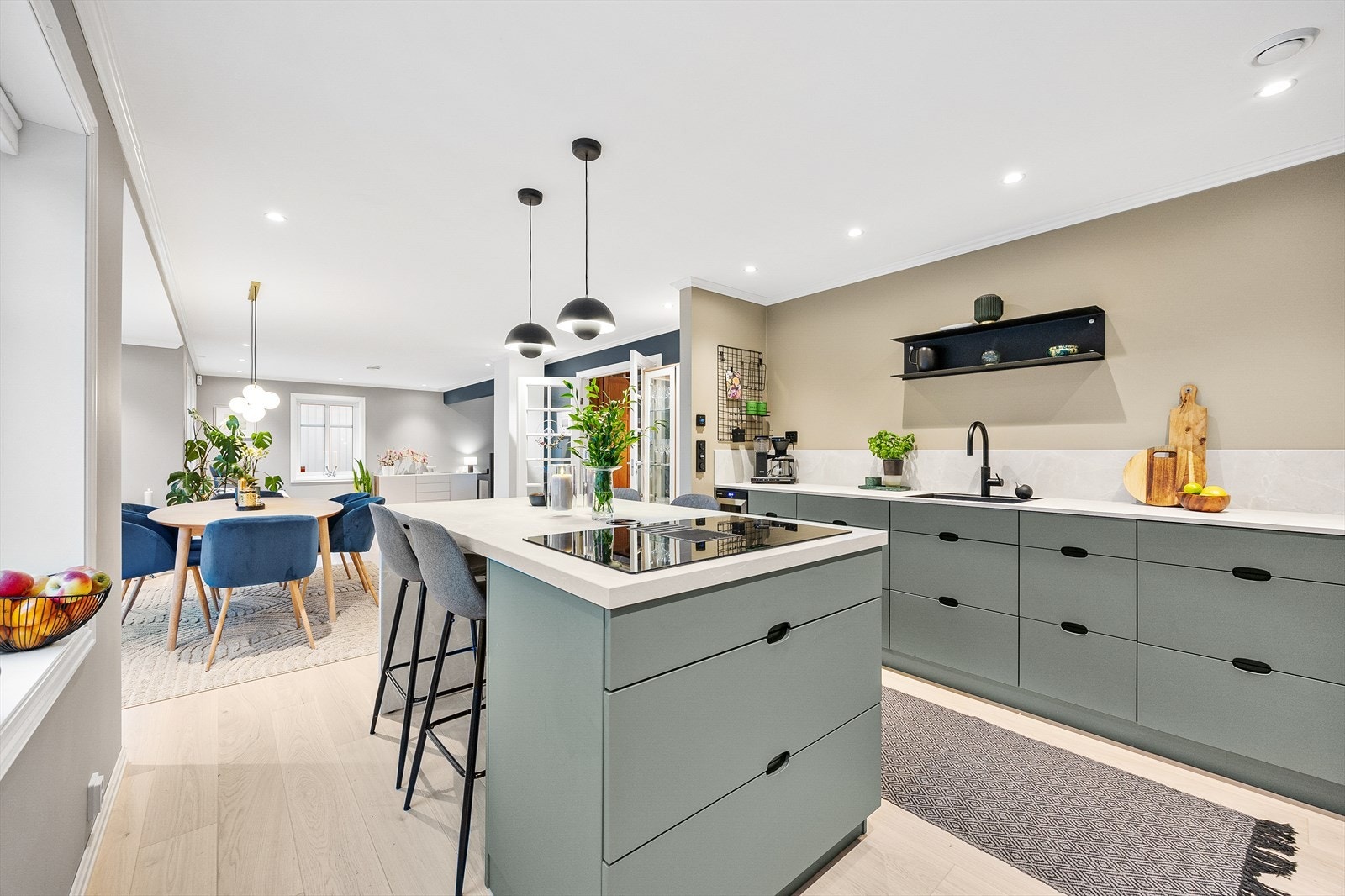 Den pent utformede kjøkkenøya gir mulighet for spiseplass og gir ekstra benkeplass til matlaging og oppbevaring. Galleribilde