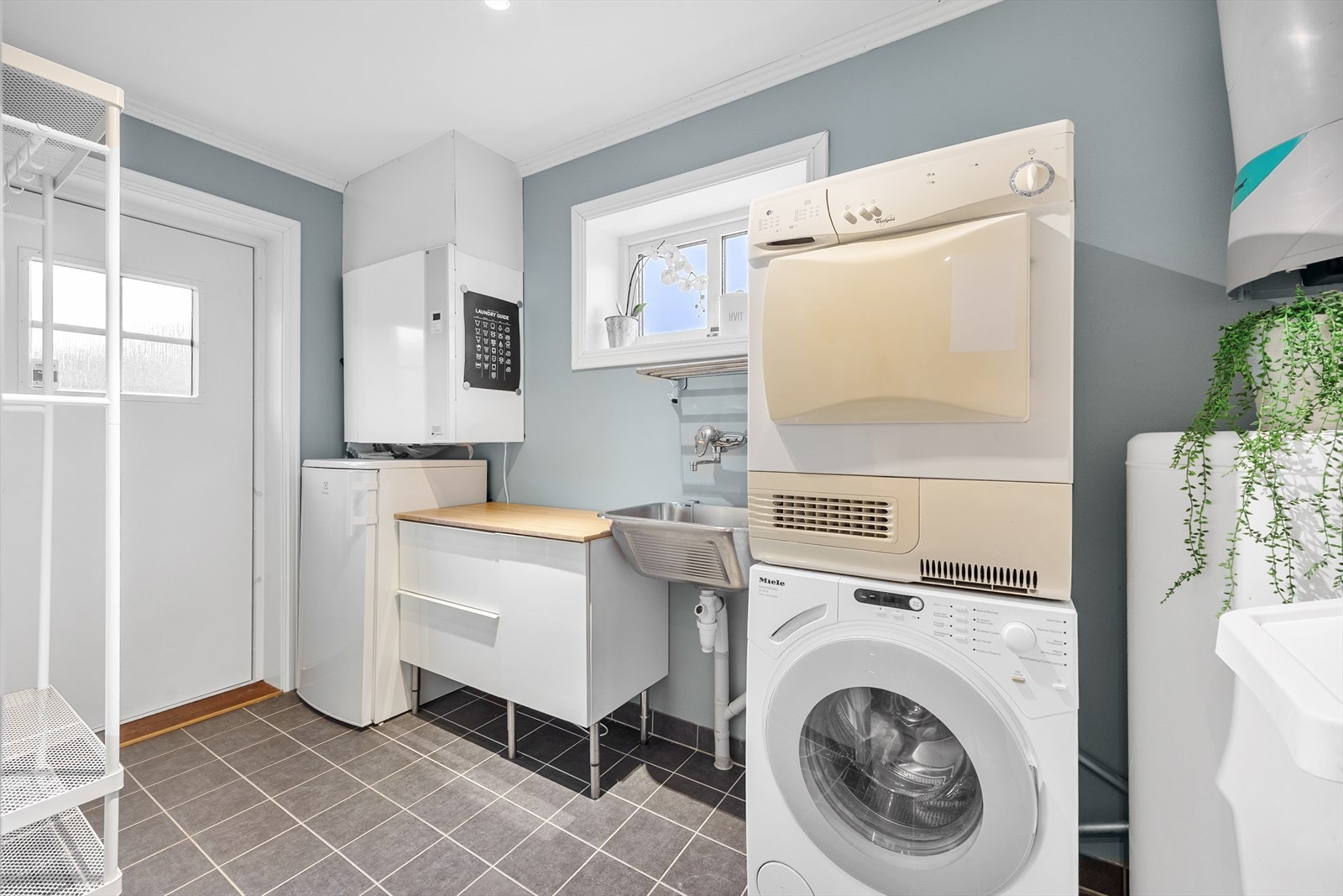 Opplegg for vaskemaskin og plass til tørketrommel, flislagt gulv og malte overflater. Galleribilde