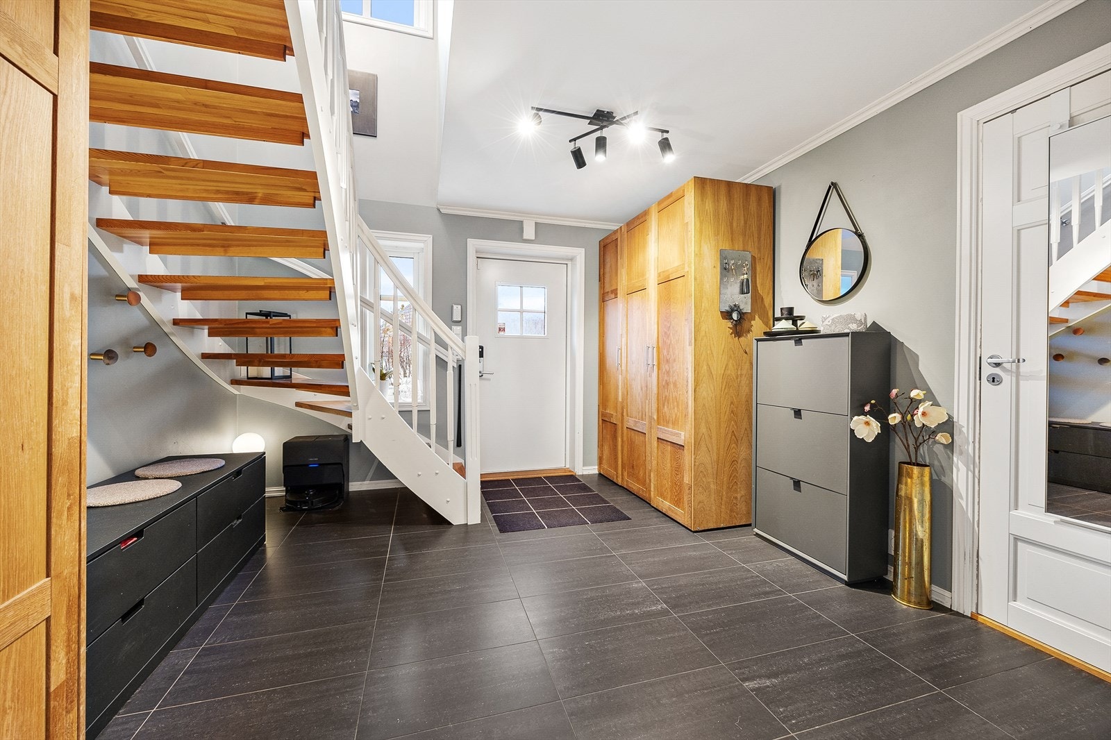 Flislagt gulv og malte overflater, samt garderobeskap med plass til oppbevaring. Galleribilde