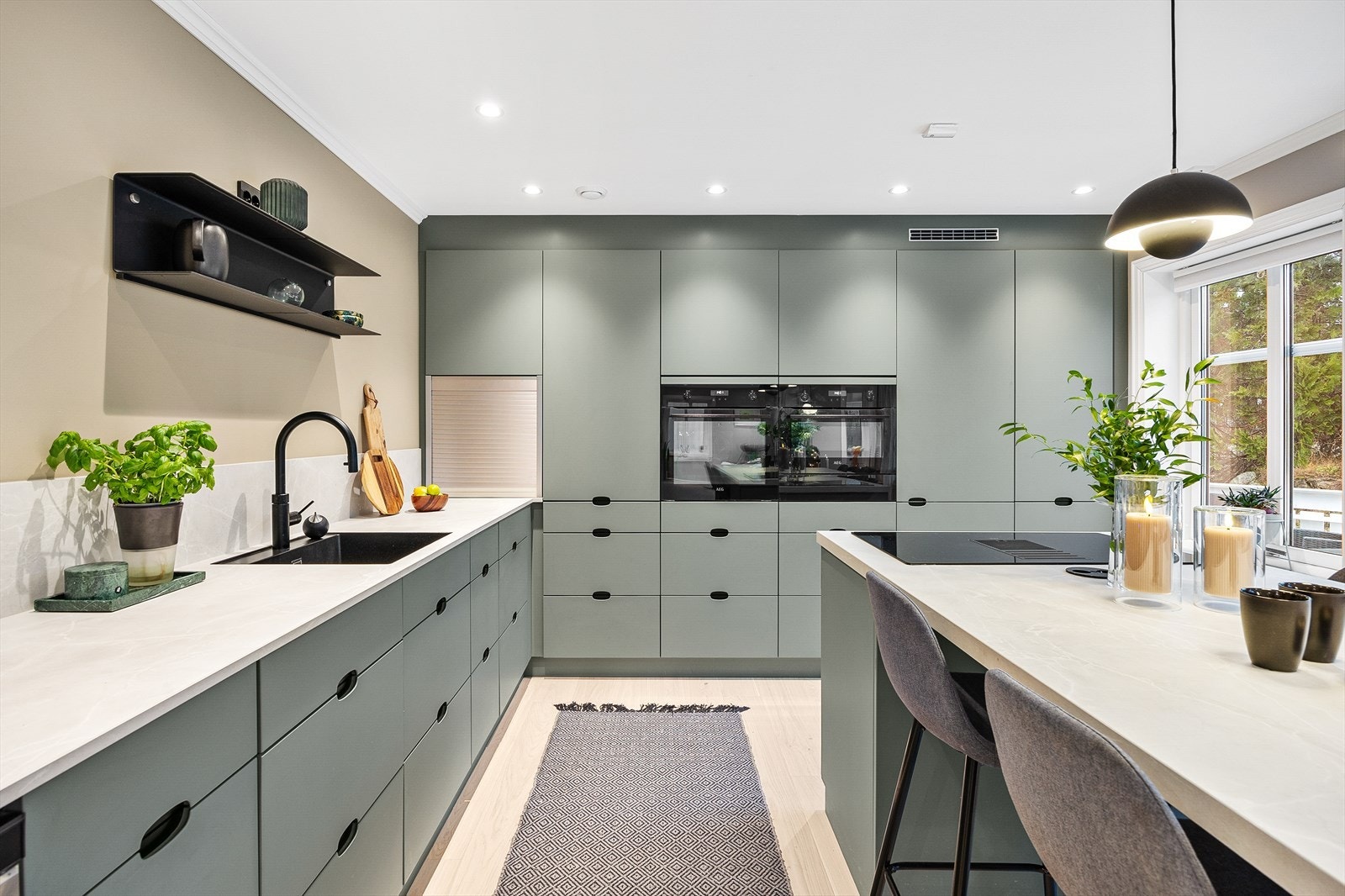 Integrerte hvitevarer som koketopp med avtrekk, stekeovn, mikrobølgeovn, vinskap og kjøleskap. Galleribilde